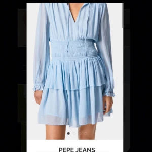 Ljusblå klänning från Pepe Jeans - Säljer en söt ljusblå klänning från Pepe Jeans med långa ärmar och v-ringad hals. Klänningen har en smockad midja och volangdetaljer som ger en fin siluett. Perfekt för en somrig look! 💙endast använd 2 gånger och köpt för 900 kr😊