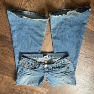 True Religion Jeans - Lågmidjade, bootcut jeans från True Religion. Dom här jeansen är verkligen så perfekta och har varit en av mina favoriter. Midjemåttet är 35,5 cm. Innerbenslängden är 84,5 cm. Ytterbenslängden är 100 cm. Grenmåttet är 17,5 cm. Över låret är 25,5 cm. Över benöppningen är 24,5 cm.