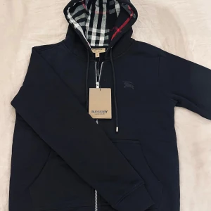 Svart hoodie från Burberry - Säljer en stilren svart hoodie från Burberry i nyskick. Hör av er vid frågor.