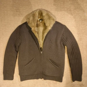 Vintage stickad Armani cardigan  - Säljer en fin pälsfodrad cardigan från Armani i topp skick. Väldigt unik och elegant med dubbla dragkedjor och snygga detaljer. Nypris runt 7000. Skriv vid minsta fundering!