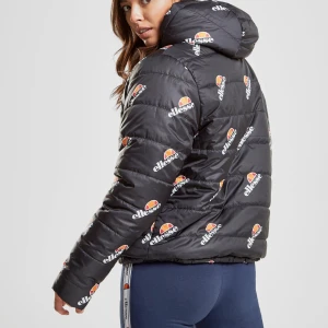 Svart vändbar dunjacka från Ellesse - Snygg svart dunjacka från Ellesse som går att vända, ena sidan är prydd med deras ikoniska logga tryckt över hela jackan och sen andra svart stilren med enbart en liten logga över vänsta bröstet. Jackan har en dragkedja och en mysig huva. Perfekt för kyliga dagar när du vill hålla stilen.