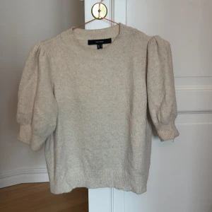 Beige tröja från Vero Moda - Säljer en stilren beige tröja från Vero Moda. Tröjan har puffiga trekvartsärmar och är tillverkad i ett mjukt material. Perfekt för en avslappnad och trendig look. 🧥