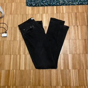 Svarta jeansbyxor från Dobber - Snygga svarta jeansbyxor från Dobber i storlek W32 L32. De har en klassisk femficksdesign och stängs med dragkedja och knapp. Perfekta för en stilren look.