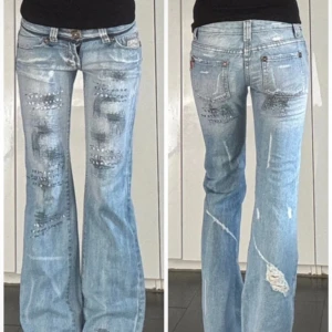 Lowrise jeans med slitningar och detaljer  - As snygga lowaisted ljusblå bootcut jeans från Riipelay med unika slitningar och detaljer. Som nya i skick och bra längd på mig som är 170🥰  storlek:27 midjemått: ca 36,5 cm (mätt platt) innerbenslängd: ca 81 cm (mätt platt) grenhöjd: ca 19 cm (mätt platt) lårbredd: ca 25 cm (mätt platt) 