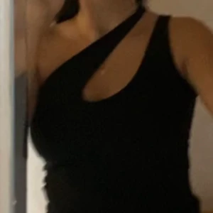 Svart oneshoulder topp från Gina Tricot - Snygg svart oneshoulder topp från Gina Tricot i ribbat material. 