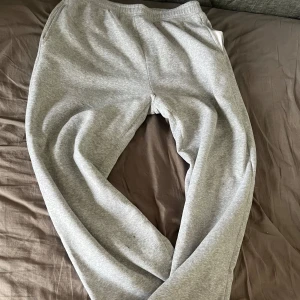 Grå mjukisbyxor  - Säljer ett par klassiska grå mjukisbyxor med resår i midjan och sidofickor. Perfekta för chill dagar eller när du vill vara extra bekväm. Mjukt material och avslappnad passform.