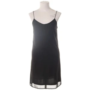 Svart slipklänning från Vero Moda XS - En svart stilren slipklänning från Vero Moda i storlek XS. Klänningen har tunna axelband, v-ringad hals med diskret mönster vid kanten och en lätt transparent nederkant. Perfekt för dig som gillar minimalistisk och trendig stil.