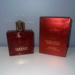 Versace Eros Flame Eau de Parfum 100ml - Versace Eros Flame Eau de Parfum i en lyxig röd glasflaska med guldigt lock och detaljer. Flaskan har ett geometriskt mönster och Medusa-huvudet ingraverat. Kommer med matchande röd kartong med guldfärgade tryck. Volym: 100 ml.
