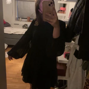 Svart glitterprickig klänning Gina Tricot - Supersöt svart kortklänning från Gina Tricot i storlek 36. Klänningen har transparenta, långärmade ärmar med små prickar och en flowy passform. Perfekt för dig som gillar en stilren look. Säljer då den inte kommer till användning mer än på kalas. Använd bara några gånger. Lätt att ha på sig och väldigt skön. Inte lika genomskinlig vid kroppen som i ärmarna (andra bilden) 🩷