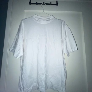 Vit oversized t-shirt från H&M - Enkel och clean vit t-shirt från H&M i oversized fit. Klassisk rund halsringning och korta ärmar. Tillverkad i mjuk bomull som känns skön mot huden. Perfekt för en chill och avslappnad stil.