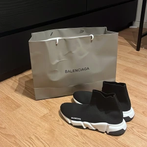 Balenciaga Skor - Säljer ett par Balenciaga Speed Trainer sneakers i svart med vit chunky sula. Skorna har en strumpliknande passform i stretchigt syntetmaterial och Balenciaga-logga på sidan. Supersnygga och futuristiska med rund tå och platt sula. Kommer med dustbag och originalpåse.