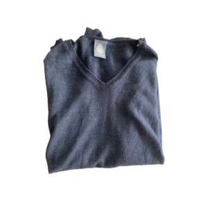 Mörkblå kashmirtröja från dondup - Mysig mörkblå kashmirtröja från Dondup med v-ringad hals. Tröjan är stickad och har en klassisk, enkel design som passar perfekt till jeans eller kjol. Superskön och stilren för dig som gillar en clean look.