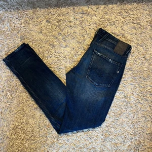 Replay Anbass jeans mörkblå herr slim fit - Säljer ett par mörkblå Replay Anbass jeans med slim  passform och snygga diskreta slitningar. Mycket bra skick, inga anmärkningar. Storlek 32 mått kan såklart skickas vid osäkerhet. Postas antigen samma dag som köp eller dagen därpå🙌💯
