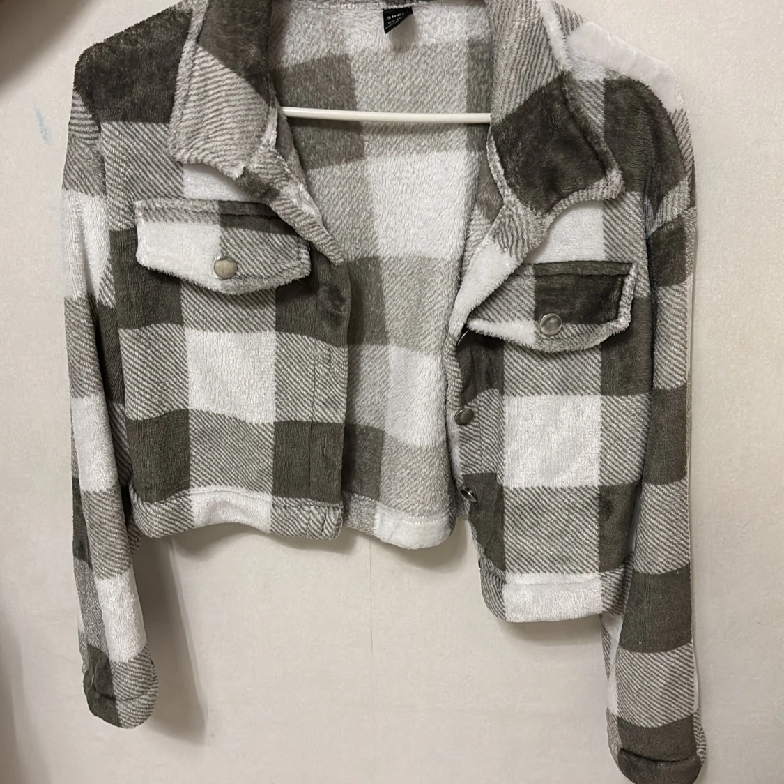 Rutig teddyjacka i grått och vitt