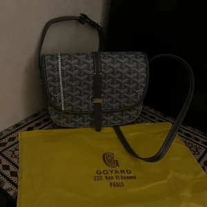 Grey unisex Axelväska  - Säljer en ikonisk grå axelväska  med deras klassiska grafiska mönster i vitt och grått. Väskan har justerbar axelrem, lock med spänne och snygga kontrastsömmar. Tillverkad i skinn och canvas, med gul dustbag från Paris.