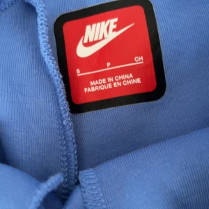 Baby blue Nike tech (PRISFÖRSLAG) - Snygga ljusblå mjukisbyxor från Nike med svart snörning i midjan och svart Nike-logga på låret. . Perfekta för chill eller träning.                         Storlek: (byxan:S/M) (koftan:XS/S)                   Skriv till mig för prisförslag.                                  Kan hämtas eller fraktas.                                        Koftan eller byxan kan köpas separat, skriv till mig för mer info då.