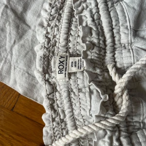 Beiga linnebyxor från Roxy - Snygga beiga linnebyxor från Roxy med bred resår och snörning i midjan. Nyskick, andvända ca 2 gånger. Köpta på Zalando för drygt 600 kr.