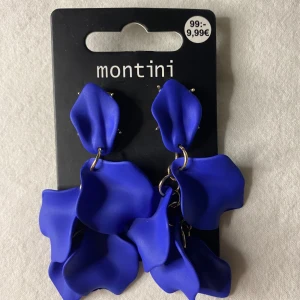 Blå blombladsörhängen - Säljer ett par blå örhängen från Montini/Ur&Penn med blomblads delar i plast och guldfärgade detaljer. Skriv om du har frågor och läs helst min bio innan du köper💕