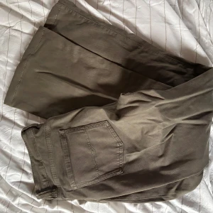 Bootcut byxor från Denim Studio, grön - Snygga lågmidjade gröna bootcut-byxor från Denim Studio som passar perfekt på mig som vanligtvis har storlek 38 i jeans. Byxorna är en petite modell som passar på mig som är 160 cm lång. Säljes då de tyvärr inte kommer till användning.