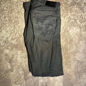 J.Lindeberg Jeans - Snygga gråa jeans från J.Lindeberg med klassisk femficksdesign och raka ben. Jeansen har en stilren look med diskreta sömmar och passform som sitter skönt på kroppen. Perfekta för dig som gillar minimalistisk stil och vill ha ett par jeans som funkar till allt.