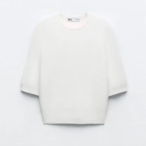 Vit stickad croppad tröja från Zara - INTRESSEKOLL! Supermjuk vit stickad tröja från Zara med rund hals och croppad passform. Tröjan har korta ärmar och ribbad kant nedtill, perfekt att styla med ett par jeans. Enkel och clean look som funkar året runt. Använd max 2-3 gånger så jättebra skick