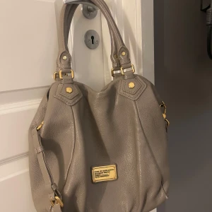 Marc by Marc Jacobs - Francesca bag - Snygg grå handväska från Marc by Marc Jacobs med guld detaljer. Jättefin väska men har ett få tal slitningar i botten och en repa på loggan, se sista bilden💕Ny pris ca 4000/5000 kr vet ej exakt då det var en present 
