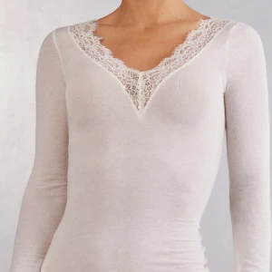 Vaniljvit långärmad topp med spets från Intimissimi - Säljer en beige långärmad topp med snygg v-ringning och dekorativ spets runt halsen. Materialet är mjukt och stretchigt💕Nypris 559 men säljer för 300