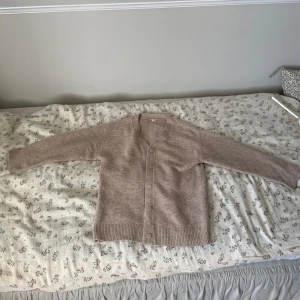 Beige stickad kofta med knappar - Säljer en beige stickad kofta från arket i storlek 134/140 men passar mig bra som oftas har storlek 146-152. Andvänt ett fåtal gånger. Inga defekter och mycket gott sick. 100% Ull. Nypris 590kr!