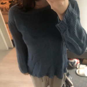 Blå stickad tröja med lång ärm - Mysig blå stickad tröja med lång ärm och rund hals. Tröjan har en enkel design med lätt vågig kant nedtill och vid ärmslut. Perfekt för dig som gillar chill och stilren look. Passar dig som vill ha något bekvämt och snyggt till vardags.