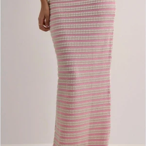En rosa kjol från Nelly - Superfin långkjol med rosa och vita ränder i stickad kvalitet. Storlek S men passar också bra för storlek M. Perfekt inför sommaren och är helt nytt! 