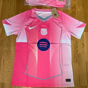 Barcelona rosa fotbollströja Nike - Snygg Barcelona fotbollströja från Nike i en fräsch rosa färg med vita och ljusblå detaljer. 