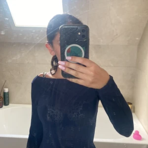 Mörkblå långärmad topp Intimissimi - Snygg mörkblå långärmad topp från Intimissimi i ultralätt material med kashmir. Modellen har offshoulder-skärning och smal passform. Perfekt för dig som gillar stilrena och enkla plagg med en twist. Materialet är mjukt och tunt, vilket gör den skön att bära.