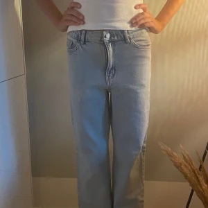 Ljusblå wide jeans med hög midja - Säljer ett par ljusblå jeans med hög midja och breda ben. Jeansen har klassisk femficksdesign, raka bakfickor och knappstängning fram. Perfekt för dig som gillar en chill och trendig look. Materialet är jeans och passformen är loose.