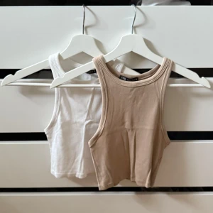 Ribbad croppad linnetopp från Zara - Två croppade linnetoppar från Zara, en i vit och en i beige i storlek S