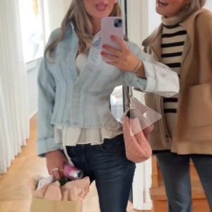 Ljusblå croppad jeansjacka - Säljer en ljusblå croppad jeansjacka med klassisk knappstängning och långa ärmar. Jackan har en snygg, figurnära passform och är tillverkad i jeansmaterial. Perfekt för dig som vill ha en chill och trendig look.