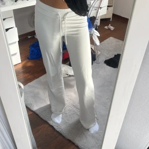 Vita mjukisbyxor med snörning - Säljer ett par vita mjukisbyxor med snörning i midjan. Byxorna har en loose passform och raka ben med lite bootcut-vibe.  Materialet känns mjukt och stretchigt, och midjan är mid. 