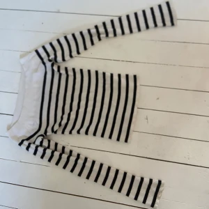 Randig offshoulder stickad tröja - Säljer en vit och svart stickad offshoulder tröja, använt få gånger. Den har mycket bra passform.