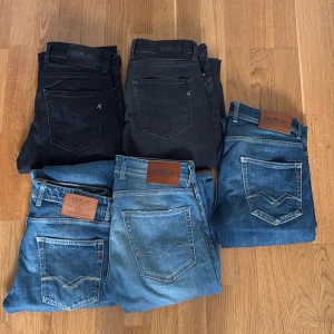 Replay jeans i olika blå och svarta toner - Fem par Replay jeans i olika tvättar, från mörksvart och grått till ljusblå och klassisk blå denim. Alla har den ikoniska Replay-loggan på bakfickan och läderpatch i midjan. Snygg passform och klassisk jeansstil, perfekta för dig som gillar street och casual. Alla är modellen Grover och är storlekar 30/32 och 31/32. Skriv om ni vill ha fler bilder och kom med bud!
