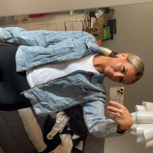 Ljusblå jeansjacka från Mango Denim - Säljer en ljusblå jeansjacka från mango Denim i klassisk modell med två stora bröstfickor och dragkedja framtill. Jackan har en loose passform och är tillverkad i jeansmaterial. 