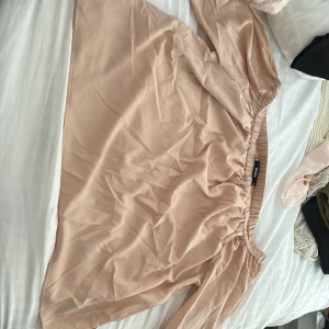 Rosa blus från Bik Bok - Säljer en superfin beige kjol från Bik Bok med elastisk midja. Blusen har en lätt och flowy känsla.