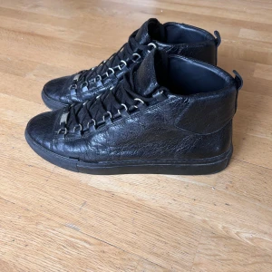 Balenciaga arena svarta sneakers - Säljer mina Balenciaga sneakers storlek 43. Skorna i sig är i ett ganska bra skick men sulorna har sprickor på yttre sidorna. Köpte de här för 1200 på second hand hemsida använt några gånger men fick tag på bättre, säljer för samma pris. Om sprickorna är ett problem går det alltid att byta de hos en skomakare som kan byta ut med identiska sulor, Dm om du har mer frågor!