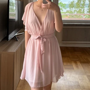 Ljusrosa omlottklänning från Bubbleroom - Snygg rosa klänning som kommer från Bubbleroom.