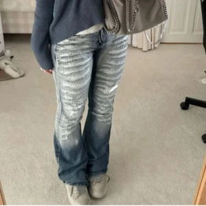 Blå bootcut jeans med slitningar - Säljer ett par blå bootcut jeans med slitningar och blekta detaljer framtill. Jeansen har tyvärr ingen lapp kvar men jag skulle säga att dom passar w26 och är något för långa för mig som är 160. 