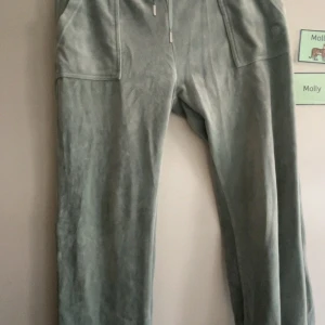 Gröna velourbyxor Juicy Couture L - Mysiga ljusgröna mjukisbyxor från Juicy Couture, fickor fram och bak. Perfekta för chill eller när du vill ha en avslappnad look. Skriv vid intresse eller mer info.
