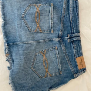   Abercrombie & fitch jeanskjol - Snygg jeanskjol från Abercrombie & Fitch med fransig kant och slitna detaljer. Jättetrendig och söt, säljer för den inte passar