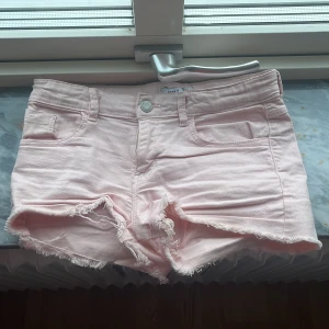 Ljusrosa jeansshorts med fransig kant - Snygga ljusrosa jeansshorts från Name It med fransig kant nertill. Shortsen har justerbar midja på insidan och superfina till sommaren. Strl är 146 men jag skulle även säga tt för passar xxs/xs pga den stretchiga midjan💗💗