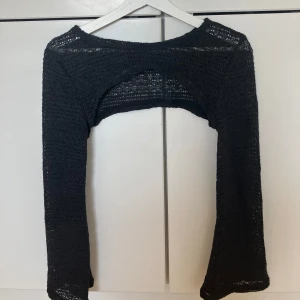 Stickad bolero i svart  - Säljer en superfin, stickad bolero i svart. Den är lätt och luftig med lång ärm och passar perfekt som en stilren detalj över linnen, klänningar eller toppar. 89kr på hemsidan. 