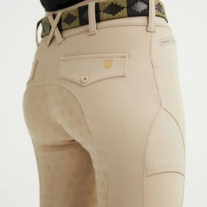 Beige ridbyxor från Maya Delorez - Snygga beige ridbyxor från Maya Delorez med diskret mönster och praktiska fickor bak. Byxorna har hög midja och är tillverkade i ett stretchigt material som ger bra passform och rörelsefrihet. Perfekta för dig som gillar ridning och vill ha stilrena detaljer.