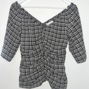  Ganni blus - Seersucker textur, v-ringning, vida ärmar, dold dragkedja i sidan och drapering