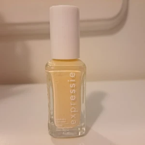 Gul nagellack Expressie Essie - Expressie nagellack från Essie i en ljusgul nyans. Kommer i en stilren, fyrkantig glasflaska med vitt lock. Snabbtorkande formula och smidig pensel för enkel applicering. Perfekt för dig som vill ha en fräsch och trendig färg på naglarna.
